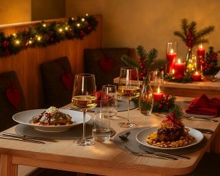 A festively decorated table with Christmas dinner and candles.
